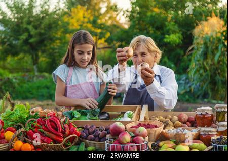 Großmutter und Enkelin verkaufen Gemüse und Obst auf dem Bauernmarkt. Selektiver Fokus. Essen. Stockfoto
