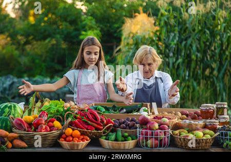 Großmutter und Enkelin verkaufen Gemüse und Obst auf dem Bauernmarkt. Selektiver Fokus. Essen. Stockfoto