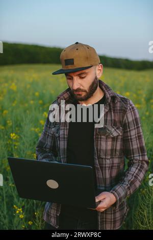 Erfolgreicher Bauer mit seinem Feld. Einsatz intelligenter Technologie für den Anbau und die Entwicklung von Pflanzen. Stockfoto