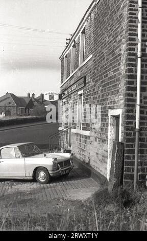 1960er Jahre, historisch, ein Triumph Herald parkte vor einem öffentlichen Haus von Wilsons, The Bulls Head, Ripponden Rd, Oldham, Lancashire, England, Großbritannien. Dieser kleine zweitürige Wagen wurde erstmals 1959 von der Standard-Triumph Company aus Coventry hergestellt und mit einer von Giovanni Michelotti entworfenen Karosserie bis 1971 in verschiedenen Ausführungen hergestellt. Stockfoto