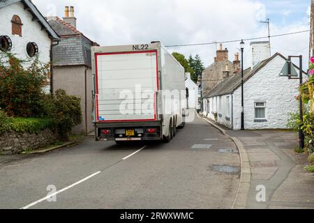 Ein Lkw, der durch die enge Dorfstraße von New Abbey in Dumfries, Schottland fährt Stockfoto
