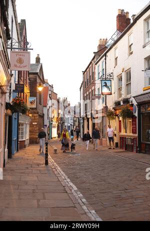 Hübsche unabhängige Geschäfte, Cafés und Bars an der Church Street in der historischen Altstadt von Whitby in North Yorkshire, Großbritannien Stockfoto