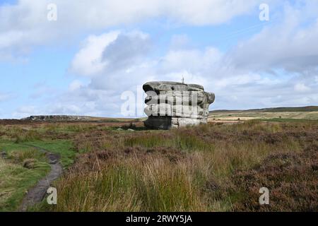 Der Eaglestone, ein Gritstone-Aufschluss an den Derbyshire Peak District Moors, ist ein Wahrzeichen für Wanderer nahe Baslow Edge. Stockfoto