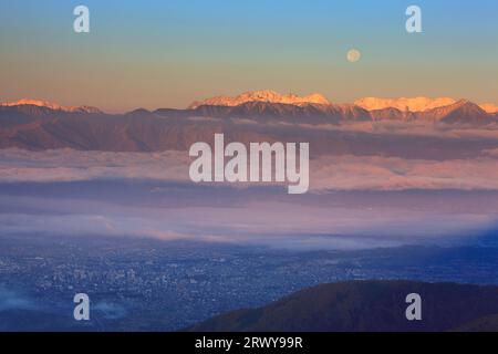 Der Mond am Morgen, die Hotaka-Bergkette, die Yarigatake-Bergkette und die Stadt Matsumoto von Ohgahana aus gesehen Stockfoto