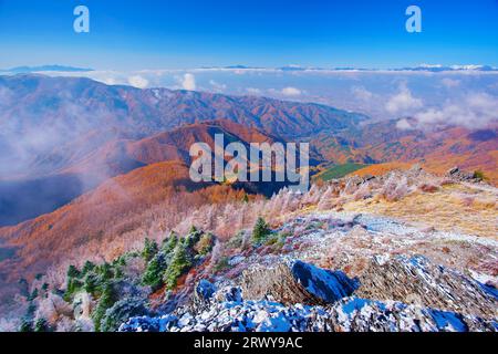 Der felsige Kamm von Oogahana mit Neuschnee, Lärchenwald mit Herbstlaub und die Hotaka-Bergkette Stockfoto