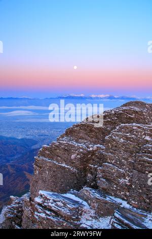 Der felsige Kamm von Oogahana mit frischem Schnee, der Mond am Morgen und ein weiter Blick auf die Hotaka-Bergkette und andere Gipfel Stockfoto