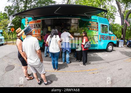 Atlanta, GA/USA - 29. April 2023: Fisheye Lens Shot zeigt Menschen, die beim jährlichen Inman Park Festival in Atlanta auf einem Food Truck in der Schlange stehen. Stockfoto