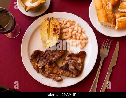 Gebratenes Lamm mit Bohnen und halber Kartoffel. Stockfoto