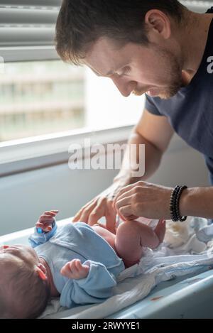 Vater wechselte Windel zu seinem neugeborenen Sohn Stockfoto