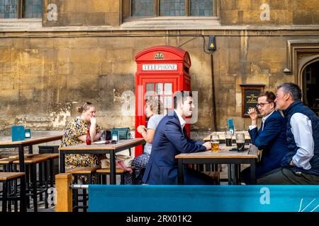 Die Leute, die sich während der Mittagszeit hinsetzen und Getränke genießen, Watling Street, Großbritannien. Stockfoto