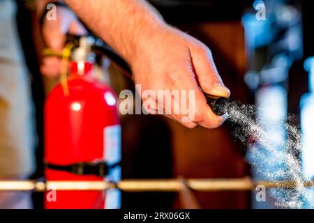 Blick von innen in einen Ofen mit selektivem Fokus auf einen Feuerlöscher, der auf das Feuer gerichtet ist. Stockfoto