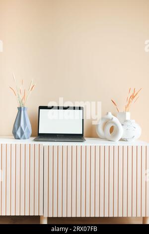 Laptop mit leerem Bildschirm auf dem Schreibtisch. Stockfoto