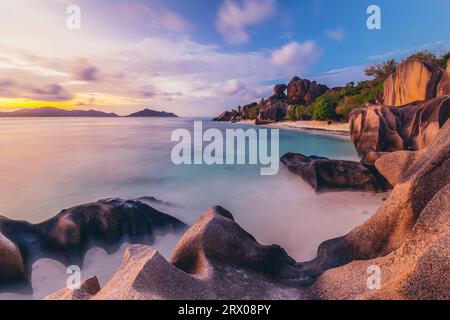 Hübsch geformte Granitfelsen und einen dramatischen Sonnenuntergang im Bild perfekte tropische Anse Source d ' Argent Strand, Insel La Digue, Seychellen. Stockfoto