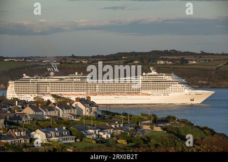 Churchbay, Crosshaven, Cork, Irland. September 2023. Bei spätabendlicher Beleuchtung passiert das Kreuzfahrtschiff MSC Preziosa die Häuser am Meer in Churchbay, Crosshaven, Co Cork geht auf eine Reise nach Hamburg. David Creedon / Alamy Live News Stockfoto