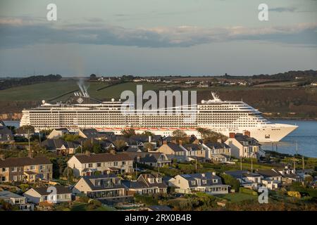 Churchbay, Crosshaven, Cork, Irland. September 2023. Bei spätabendlicher Beleuchtung passiert das Kreuzfahrtschiff MSC Preziosa die Häuser am Meer in Churchbay, Crosshaven, Co Cork geht auf eine Reise nach Hamburg. David Creedon / Alamy Live News Stockfoto