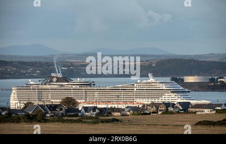 Churchbay, Crosshaven, Cork, Irland. September 2023. Bei spätabendlicher Beleuchtung passiert das Kreuzfahrtschiff MSC Preziosa die Häuser am Meer in Graball Bay, Crosshaven, Co Cork geht auf eine Reise nach Hamburg. David Creedon / Alamy Live News Stockfoto