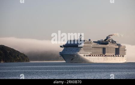 Cobh, Cork, Irland. September 2023. Das Kreuzfahrtschiff MSC Preziosa kommt im Hafen von Cork unter einer Nebelbank an, während sie zum Tiefwasserplatz in Ringaskiddy, Co. Cork fährt. David Creedon / Alamy Live News Stockfoto