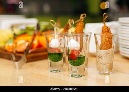 Set aus Caprese-Canapés in Shots, Party-Snacks in Gläsern auf einem Tisch in einem Café, Vorspeisen und Fingerfood Stockfoto