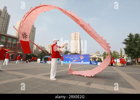 Luannan County, China - 12. August 2022: Die Menschen winken Bänder, um auf dem Platz Sport zu treiben. Stockfoto