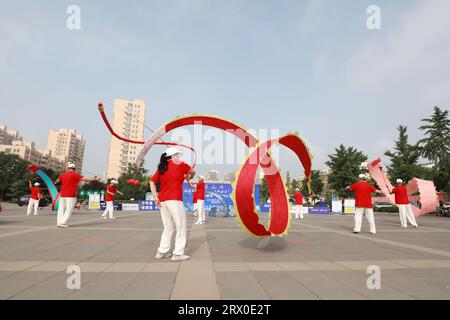 Luannan County, China - 12. August 2022: Die Menschen winken Bänder, um auf dem Platz Sport zu treiben. Stockfoto