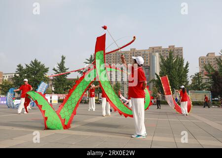 Luannan County, China - 12. August 2022: Die Menschen winken Bänder, um auf dem Platz Sport zu treiben. Stockfoto