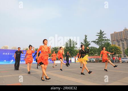 Luannan County, China - 12. August 2022: Die Menschen winken Bänder, um auf dem Platz Sport zu treiben. Stockfoto