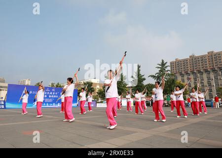 Luannan County, China - 12. August 2022: Die Menschen winken Bänder, um auf dem Platz Sport zu treiben. Stockfoto