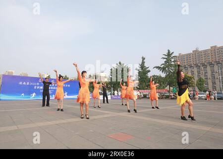 Luannan County, China - 12. August 2022: Die Menschen winken Bänder, um auf dem Platz Sport zu treiben. Stockfoto