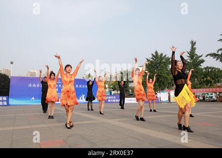 Luannan County, China - 12. August 2022: Die Menschen winken Bänder, um auf dem Platz Sport zu treiben. Stockfoto