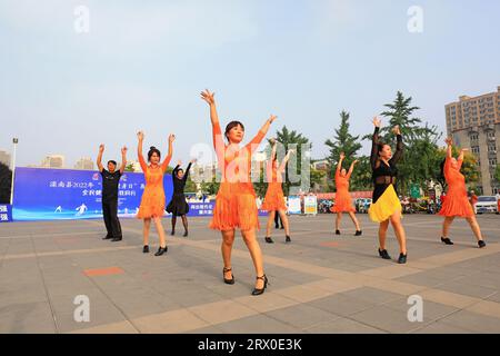 Luannan County, China - 12. August 2022: Die Menschen winken Bänder, um auf dem Platz Sport zu treiben. Stockfoto