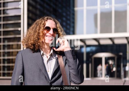 Lächelnder junger Geschäftsmann, der mit dem Handy spricht Stockfoto