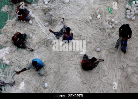 20. September 2023, Chittagong, Karnaphuli River, Bangladesch: Fischer, die Netze reparieren, um im Meer zu fischen, sitzen auf dem Sandbagger im Karnaphuli-Fluss von Chittagong, Bangladesch. (Bild: © Mohammed Shajahan/ZUMA Press Wire) NUR REDAKTIONELLE VERWENDUNG! Nicht für kommerzielle ZWECKE! Stockfoto