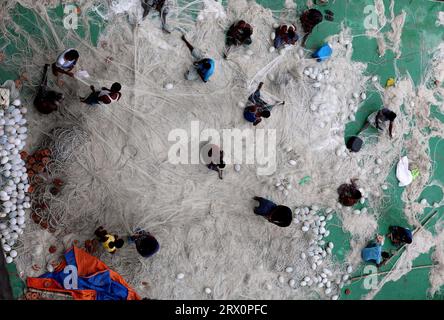 20. September 2023, Chittagong, Karnaphuli River, Bangladesch: Fischer, die Netze reparieren, um im Meer zu fischen, sitzen auf dem Sandbagger im Karnaphuli-Fluss von Chittagong, Bangladesch. (Bild: © Mohammed Shajahan/ZUMA Press Wire) NUR REDAKTIONELLE VERWENDUNG! Nicht für kommerzielle ZWECKE! Stockfoto