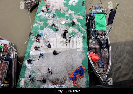 20. September 2023, Chittagong, Karnaphuli River, Bangladesch: Fischer, die Netze reparieren, um im Meer zu fischen, sitzen auf dem Sandbagger im Karnaphuli-Fluss von Chittagong, Bangladesch. (Bild: © Mohammed Shajahan/ZUMA Press Wire) NUR REDAKTIONELLE VERWENDUNG! Nicht für kommerzielle ZWECKE! Stockfoto