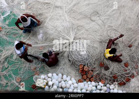 20. September 2023, Chittagong, Karnaphuli River, Bangladesch: Fischer, die Netze reparieren, um im Meer zu fischen, sitzen auf dem Sandbagger im Karnaphuli-Fluss von Chittagong, Bangladesch. (Bild: © Mohammed Shajahan/ZUMA Press Wire) NUR REDAKTIONELLE VERWENDUNG! Nicht für kommerzielle ZWECKE! Stockfoto