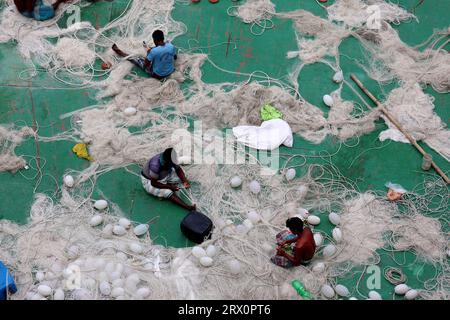 20. September 2023, Chittagong, Karnaphuli River, Bangladesch: Fischer, die Netze reparieren, um im Meer zu fischen, sitzen auf dem Sandbagger im Karnaphuli-Fluss von Chittagong, Bangladesch. (Bild: © Mohammed Shajahan/ZUMA Press Wire) NUR REDAKTIONELLE VERWENDUNG! Nicht für kommerzielle ZWECKE! Stockfoto