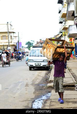 Ein madagassischer Mann mit frisch gebackenen französischen Baguettes in Moramanga, Madagaskar. Stockfoto