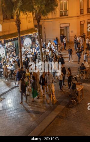 Malaga bei Nacht, Nachtleben auf den Straßen der Altstadt. Menschen gehen, sitzen in Restaurants, essen und trinken. Europa, Spanien. Stockfoto