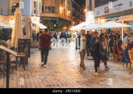 Malaga bei Nacht, Nachtleben auf den Straßen der Altstadt. Menschen gehen, sitzen in Restaurants, essen und trinken. Europa, Spanien. Stockfoto