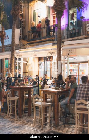 Malaga bei Nacht, Nachtleben auf den Straßen der Altstadt. Menschen gehen, sitzen in Restaurants, essen und trinken. Europa, Spanien. Stockfoto