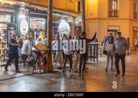 Malaga bei Nacht, Nachtleben auf den Straßen der Altstadt. Menschen gehen, sitzen in Restaurants, essen und trinken. Europa, Spanien. Stockfoto