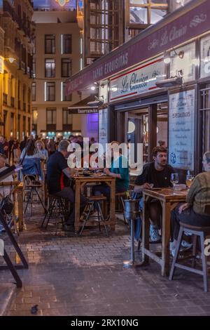 Malaga bei Nacht, Nachtleben auf den Straßen der Altstadt. Menschen gehen, sitzen in Restaurants, essen und trinken. Europa, Spanien. Stockfoto