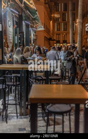 Malaga bei Nacht, Nachtleben auf den Straßen der Altstadt. Menschen gehen, sitzen in Restaurants, essen und trinken. Europa, Spanien. Stockfoto