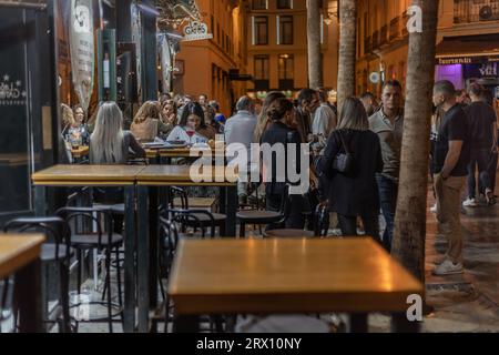 Malaga bei Nacht, Nachtleben auf den Straßen der Altstadt. Menschen gehen, sitzen in Restaurants, essen und trinken. Europa, Spanien. Stockfoto