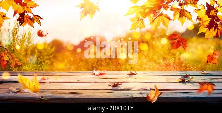 Herbst – Leaves Branch Auf Holztisch Bei Sonnenuntergang Mit Abstrakten, Unscharfen Lichtern Und Glitzereffekt Stockfoto