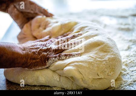 Hände Teig. Weibliche Hände machen Teig für Pizza. Der Küchenchef in der professionellen Küche bereitet Teig zu. Zubereitungsteige Stockfoto