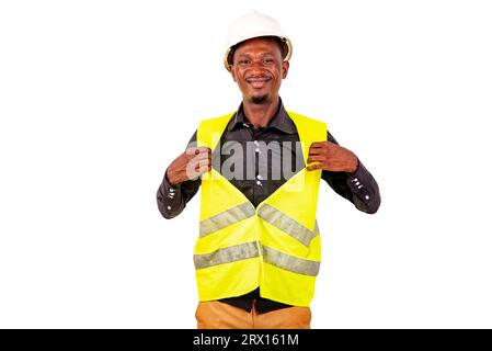 Porträt eines jungen Bauingenieurs, der seine grüne Sicherheitsweste beim Lächeln zeigt. Stockfoto