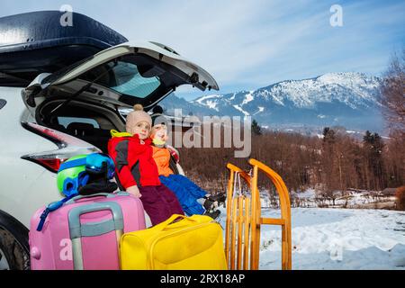 Zwei glückliche Kinder im Kofferraum, die sich für einen alpinen Schneerub verkleidet haben Stockfoto