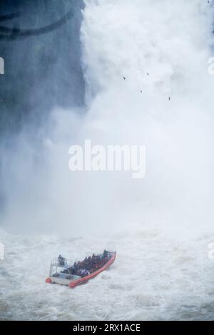 Iguazú Wasserfälle, Boot mit Touristen vor einem mächtigen Wasserstrom, der die Klippen hinunter fällt. Grenze zu Argentinien und Brasilien. Parana Stockfoto