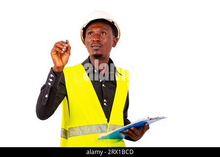 Hände eines jungen männlichen Inspektorenarchitekten, der eine Weste trägt, während er Klemmbrett hält und im leeren Raum schreibt. Stockfoto